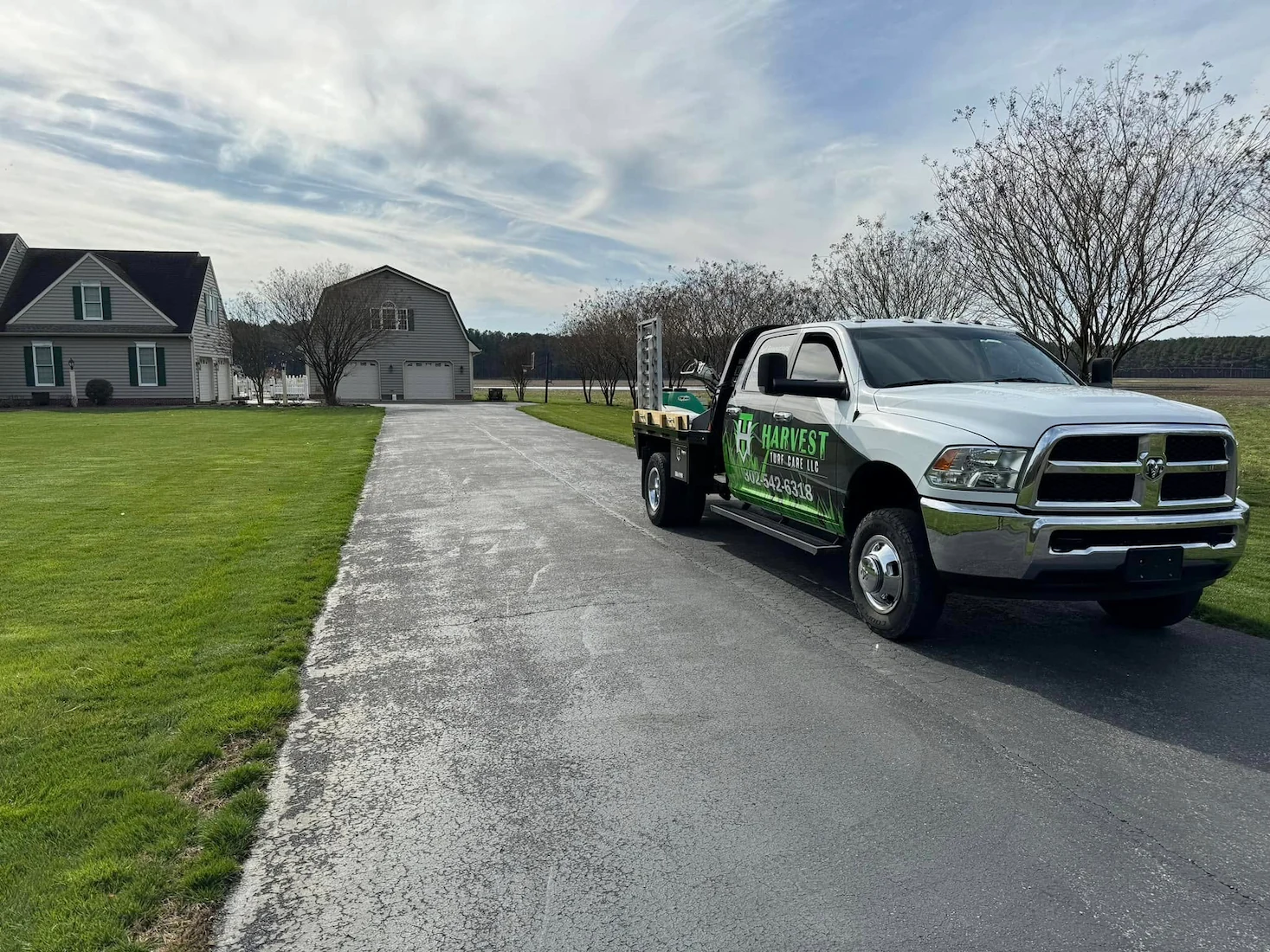 Harvest Turf Care truck parked in driveway beside healthy lawn in Sussex County DE