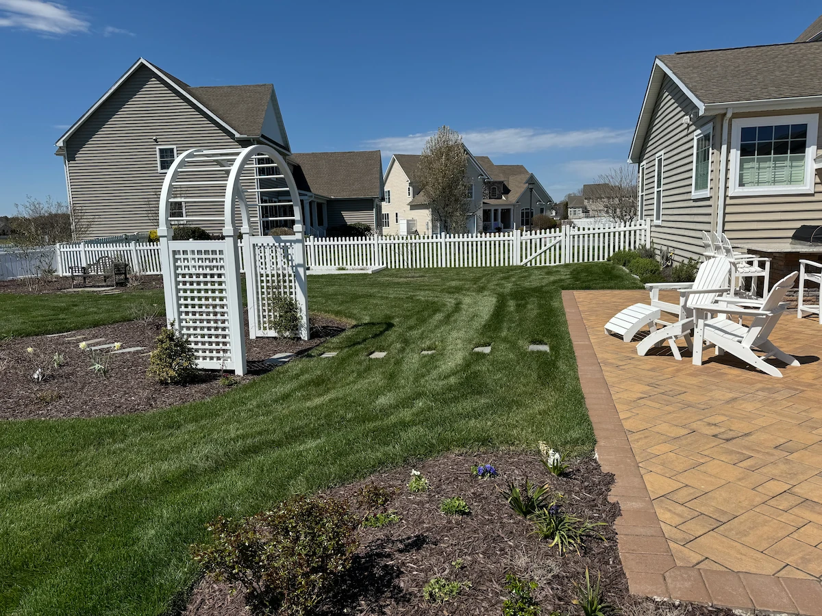 Freshly renovated backyard lawn with striped grass near patio by Harvest Turf Care for Lawn Renovations sod installation in Sussex County DE